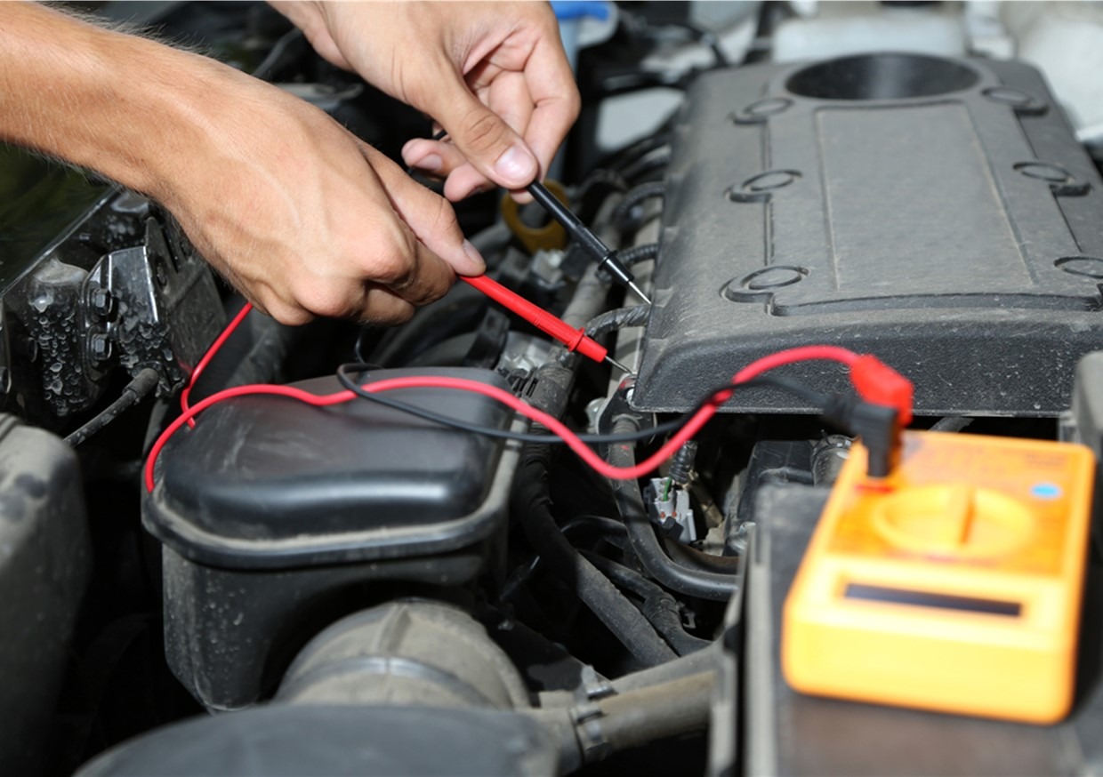 A picture of a mechanic repairing a battery. Merseyside Car Repairs offer high quality affordable car batteries to get you back on the road when your battery fails.