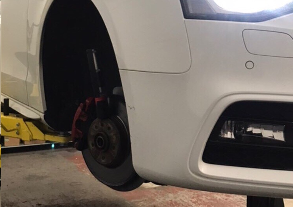 An image of a mechanic repairing brakes. Faulty breaks can cause major accidents and the consequences of not maintaining an effective braking system could result in prosecution. Get your brakes checked by us, based in Liverpool but covering areas like Prenton.